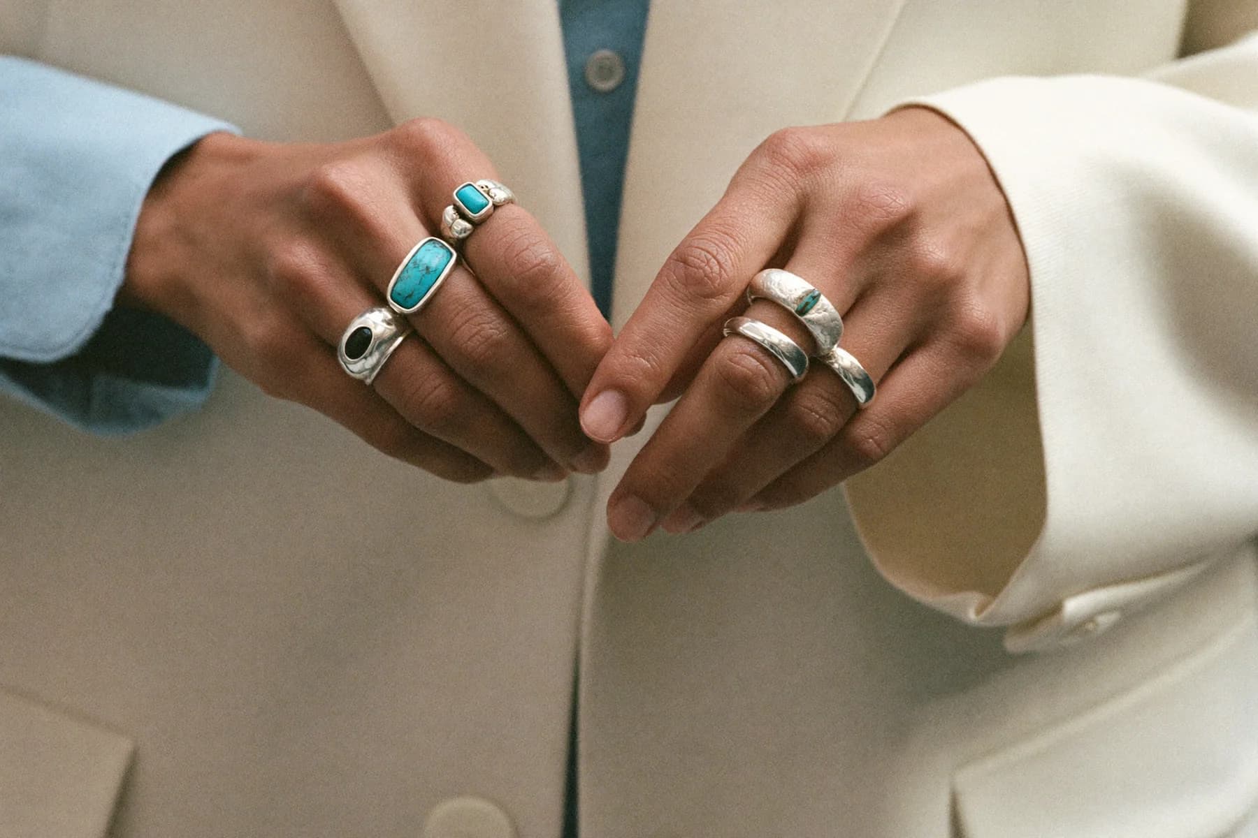 Two hands adjusting stacked sterling silver rings